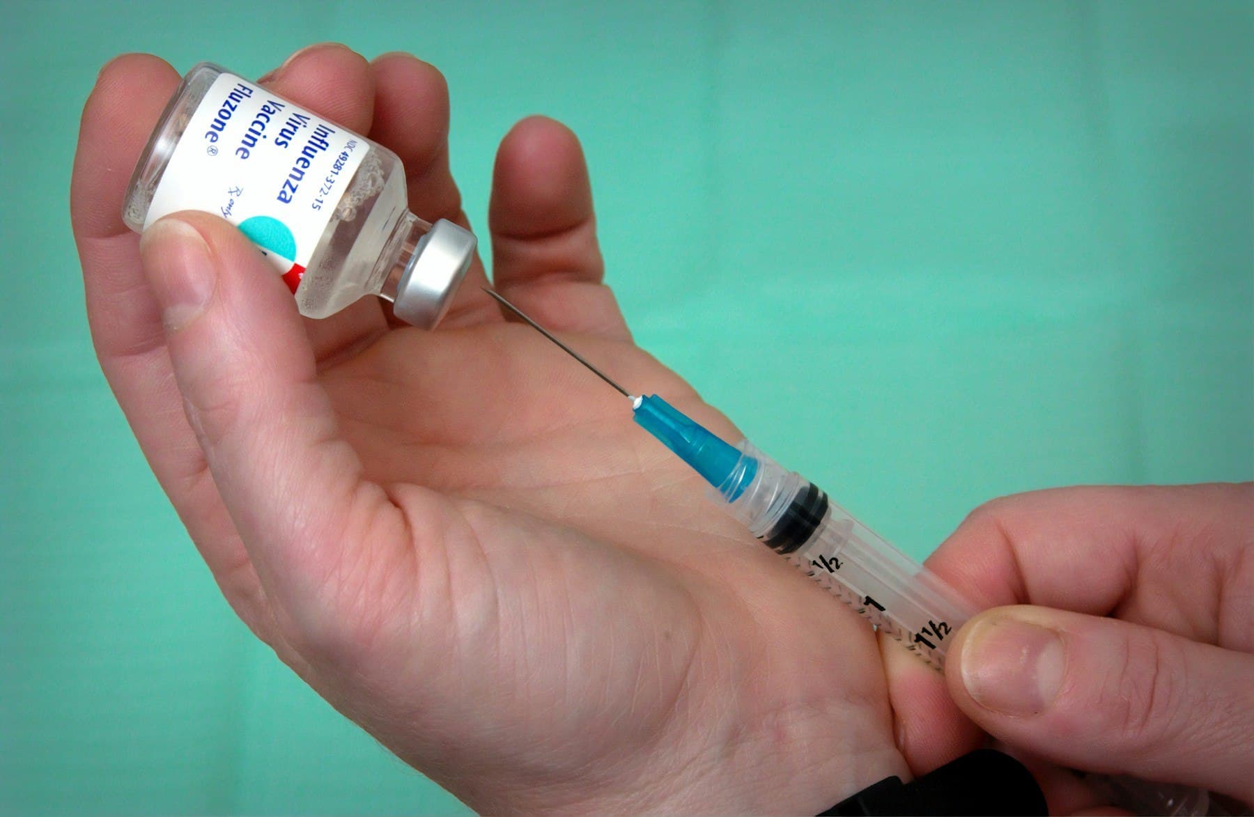 Healthcare professional preparing a vaccine using a syringe